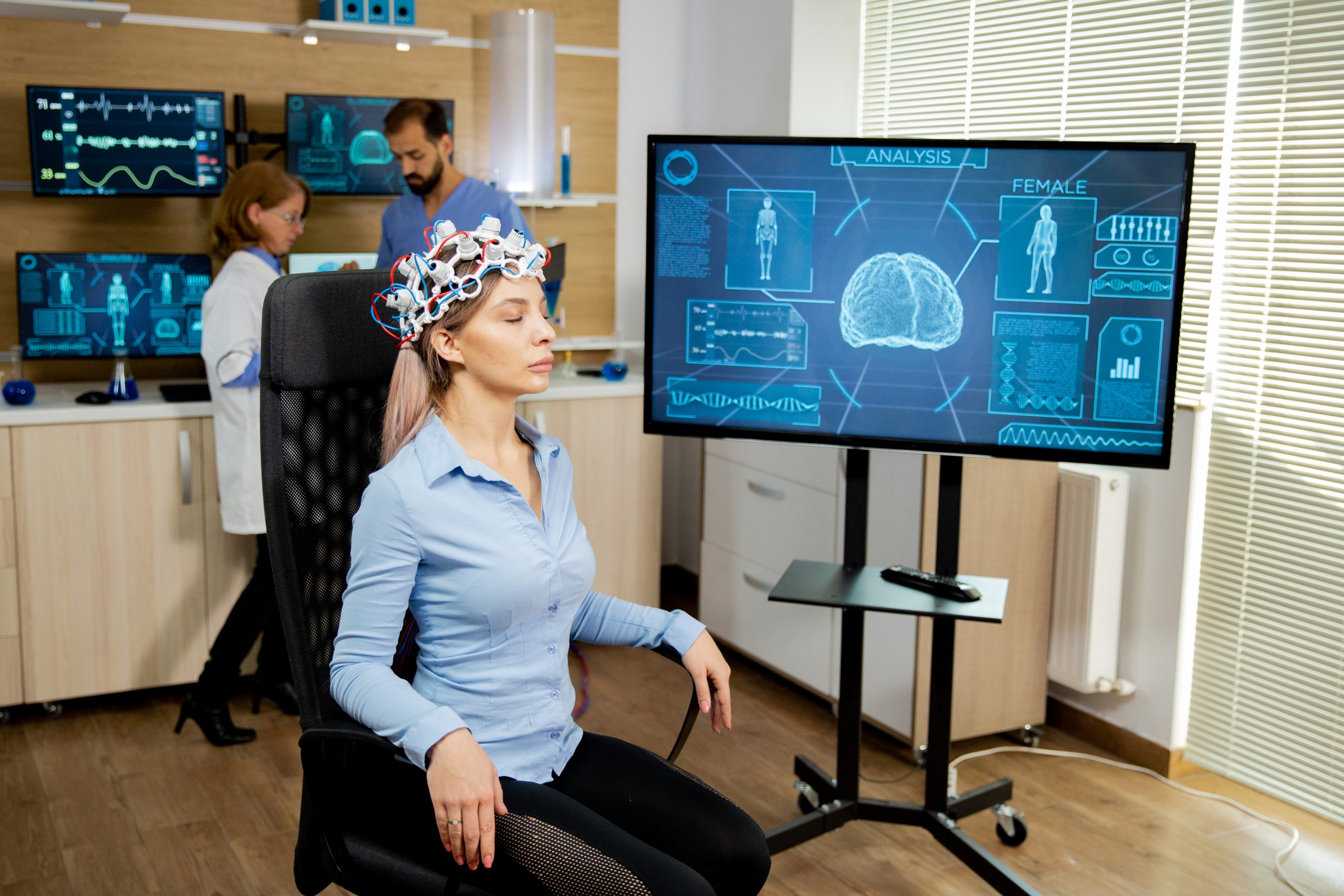 Patient woman with head scanning device and brain activity is seen on screen. Neurology diagnosis equipment